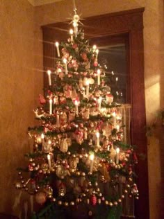 a decorated christmas tree with candles and ornaments