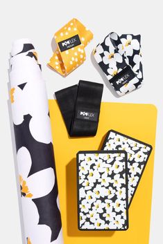 an assortment of accessories including napkins, cell phone cases and other items are laid out on a yellow surface