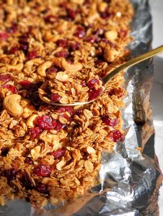 a close up of granola on a piece of tin foil with a spoon in it