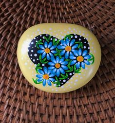 a painted heart shaped box sitting on top of a wicker table