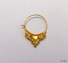 a pair of gold hoop earrings on a white surface with the word love written below it