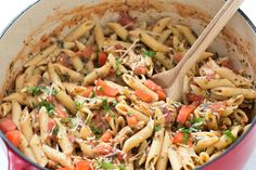 a red pot filled with pasta and vegetables