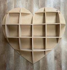 a heart shaped book shelf with several compartments on the top and bottom, made out of cardboard