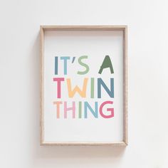 it's a twin thing print in a wooden frame on the wall next to a potted plant