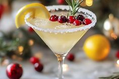 a martini with cranberries and rosemary garnish