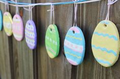 easter egg ornaments hung on a wooden fence