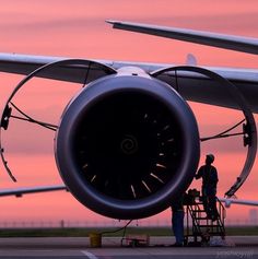 a man standing next to an airplane engine