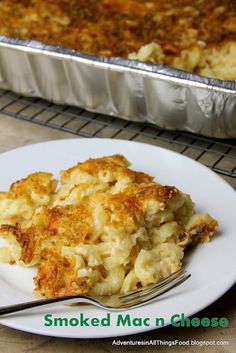 a white plate topped with macaroni and cheese next to a pan of food