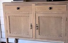 a wooden cabinet with two drawers and a tv on top of it, in front of a white wall