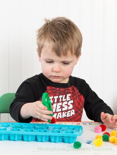 a young boy is playing with plastic blocks