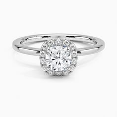 a round cut diamond ring with halos on the shoulders and sides, set in white gold