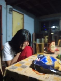 a woman sitting at a table with food and drinks