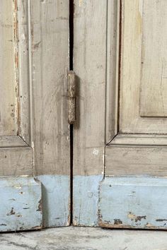 an old wooden door with a rusted handle on the front and side doors are painted white