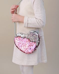 Carrying your belongings doesn't have to be boring, it can actually be magical. This open hear bag is great to take a few things on the go. 7'' W x 6'' H 20'' shoulder strap length Zip closure Spot clean Heart Crossbody Bag, Heart Purse, Sequin Mask, Rainbow Leggings, Pink Tutu Dress, Sequin Purse, Sequin Leggings, Twirly Dress, Girls Heart