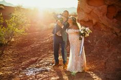 a bride and groom taking pictures in the desert