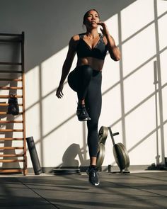 a woman in black sports bra top and leggings doing exercises on the floor