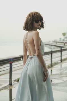 Our stylish, must-have version of the essential LBD (little ​beach dress), the Sage Maxi Dress Baby Blue is a flowing asymmetric dream that’s perfect for mid-summer events, beach days, and travel. The silhouette is inspired by the tranquil vibes of Tulum’s beaches and bustling energy of its town center. It features long straps you can wrap twice around the waist for an adjustable fit. Breathable fibers keep you cool as you lounge, explore, and indulge all summer long. Flowy V-neck Backless Dress For Beach, Summer V-neck Backless Dress For Beach, Light Blue V-neck Midi Dress For Beach, Summer Backless V-neck Dress For Beach, Summer V-neck Backless Dress For Day Out, Light Blue Flowy Summer Dress, Backless Summer Dresses For Beach Season, Light Blue Summer Vacation Dress, Casual Blue Summer Dress