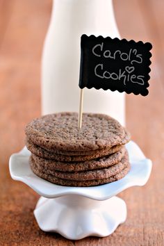 a stack of cookies sitting on top of a white plate next to a bottle of milk