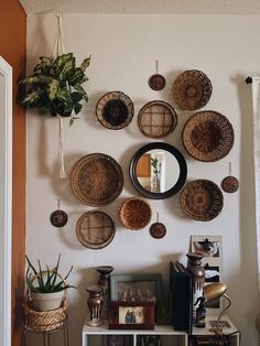 the wall is decorated with wicker baskets and hanging on it's sideboard