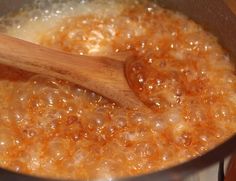 a wooden spoon in a pot filled with food