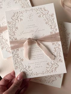 the wedding stationery is laid out on top of each other with ribbon and bow