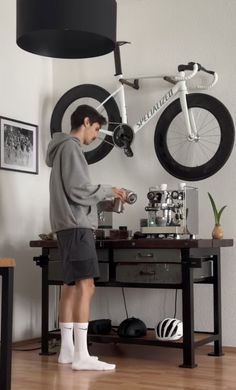 a man standing in front of a desk with a bike on it