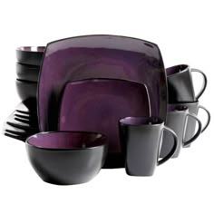 a purple and black dinnerware set with cups