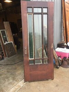 an old wooden door with glass is in the process of being repaired and repurposed