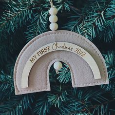 a felt ornament hanging from a christmas tree with a rainbow in the middle