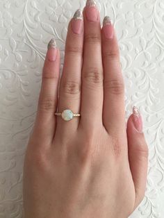 Handmade 14K yellow gold solitaire ring featuring a round opal cabochon measuring 7 mm, flanked by round brilliant cut diamonds weighing 0.04 ct (G/VS2,SI1). 1.7 mm high polish band, size 6, can be re-sized. (extra charge for size 8+) Please convo me for details. Finish can be customized to matte or hammered. Also available in 14K or 18K (any color), platinum and palladium. Made to order. SKU 12-100741 White Solitaire Moonstone Ring, Elegant Ethiopian Opal Rings In Yellow Gold, 14k Gold Opal Ring With Round Cut Center Stone, Yellow Gold Opal Ring With Brilliant Cut As Gift, White Gold Solitaire Opal Ring With Round Cut, Yellow Gold Opal Ring With Round Gemstone, Classic Round Cut Opal Birthstone Ring, Yellow Gold Opal Ring With Brilliant Round Cut, Yellow Gold Opal Ring With Brilliant Cut For Gift