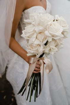 a bride holding a bouquet of white flowers