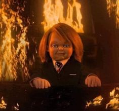 an animated doll wearing a suit and tie in front of a fire filled wall with flames