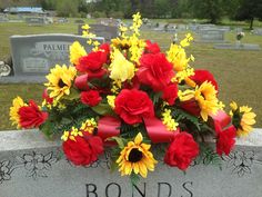 a bunch of flowers sitting on top of a headstone