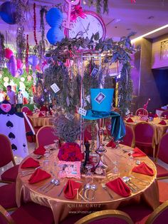 a table set up for a party with red napkins and place settings on it