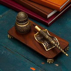 a wooden stand with two metal objects on it and books in the backgroud