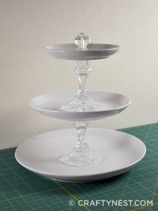 three tiered glass cake plate on top of a green cutting board with white walls