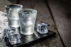 three ice cubes and one glass on a tray