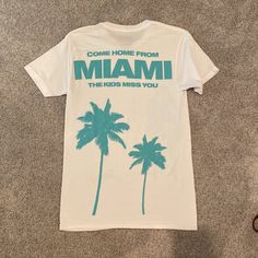 Brand New Come Home The Kids Miss You Miami T-Shirt Teal Size Small Jack Harlow T Shirt, Summer Fan Apparel T-shirt With Logo Print, Summer Fan Apparel Tops With Logo Print, Summer Logo Print Fan Apparel Tops, White Fan Merchandise T-shirt For Summer, White Slogan Tops For Fan Apparel, Summer White T-shirt For Fan Merchandise, Miami, Colorful Shirts