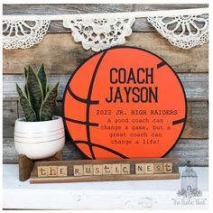 a personalized basketball plaque on a shelf next to a potted plant