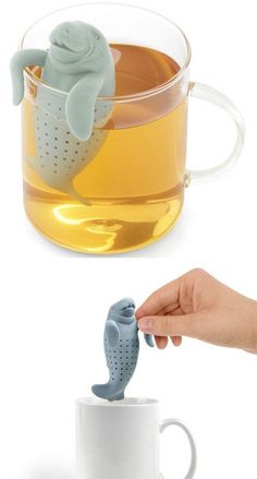 a tea infuser is being used as a strainer to pour water into a cup