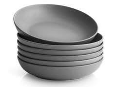 stack of gray bowls sitting on top of each other in front of a white background