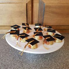 a white plate topped with black and gold graduation caps