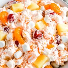 a white bowl filled with fruit salad and marshmallows on top of it