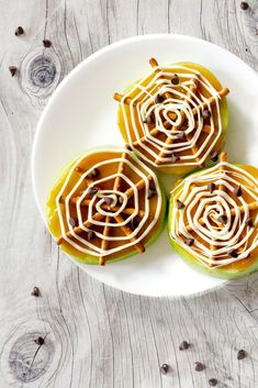 three cupcakes on a plate with white icing