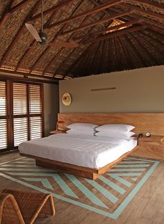 a large bed sitting inside of a bedroom on top of a wooden floor