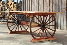 two wooden wagon wheels sitting next to each other on top of cement floored ground