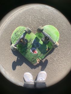 the skateboard is laying on the ground with someone's feet in front of it