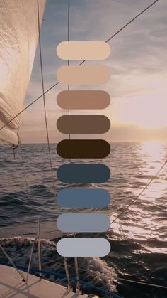 the sun is setting over the ocean and there are many different colors on the sail