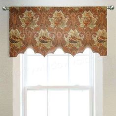 a window with an orange and gold valance hanging from it's side in front of a white wall