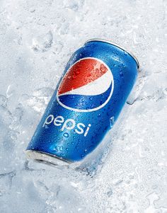 a can of pepsi on ice with water droplets